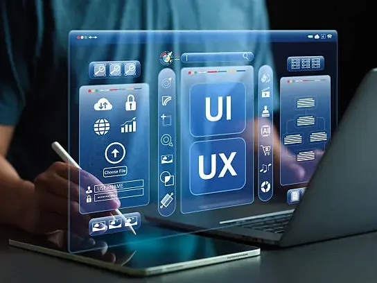 A designer with a stylus and laptop working on floating interface screens